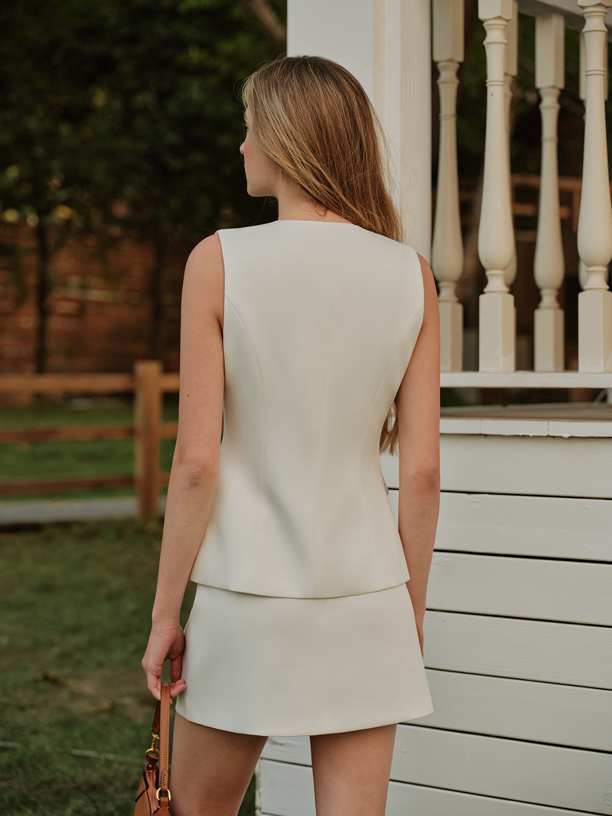 Set elegant mouwloos vest en rok met metalen knopen en split